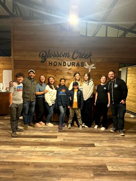 The team gathered under the Blossom Creek sign inside the mill